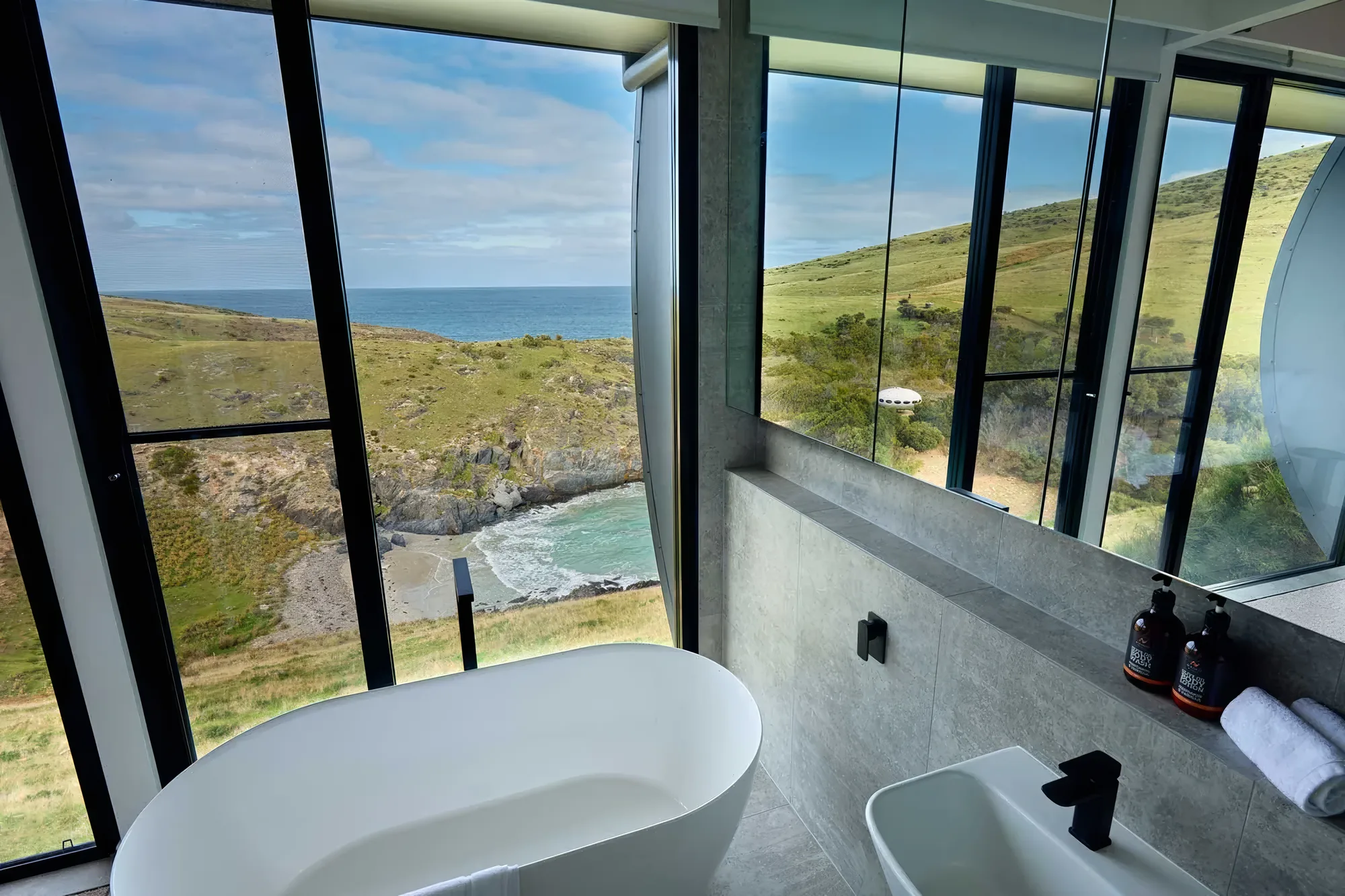Ensuite bath and walk-in shower with a sea outlook