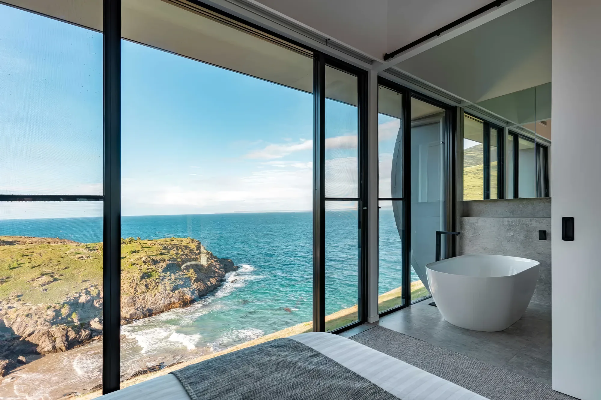 Bedroom and freestanding bath with an uninterrupted ocean outlook