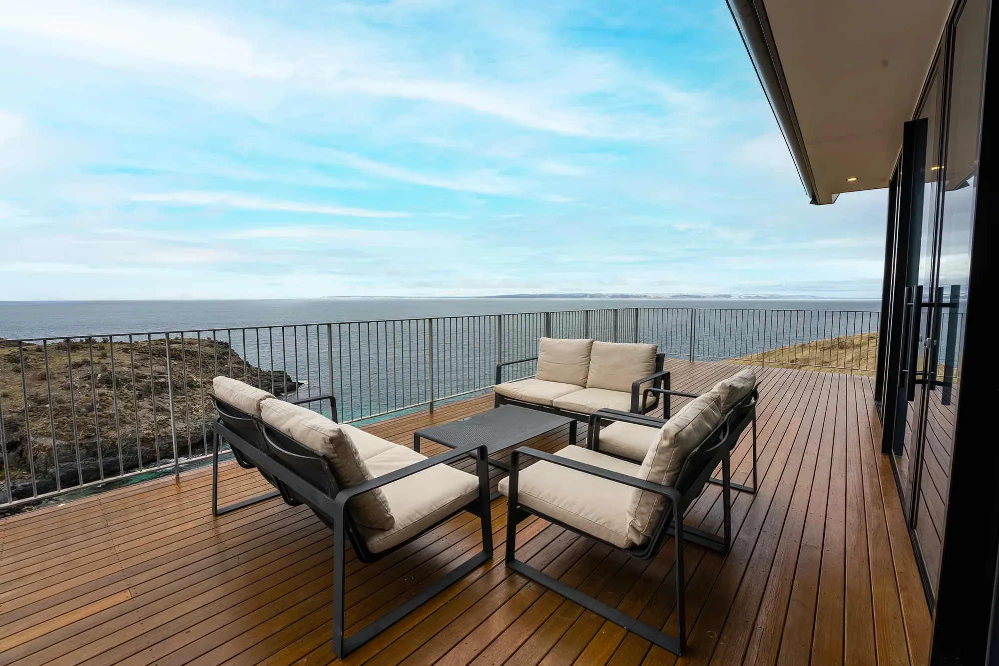 Outdoor lounge furniture on the deck facing the sea
