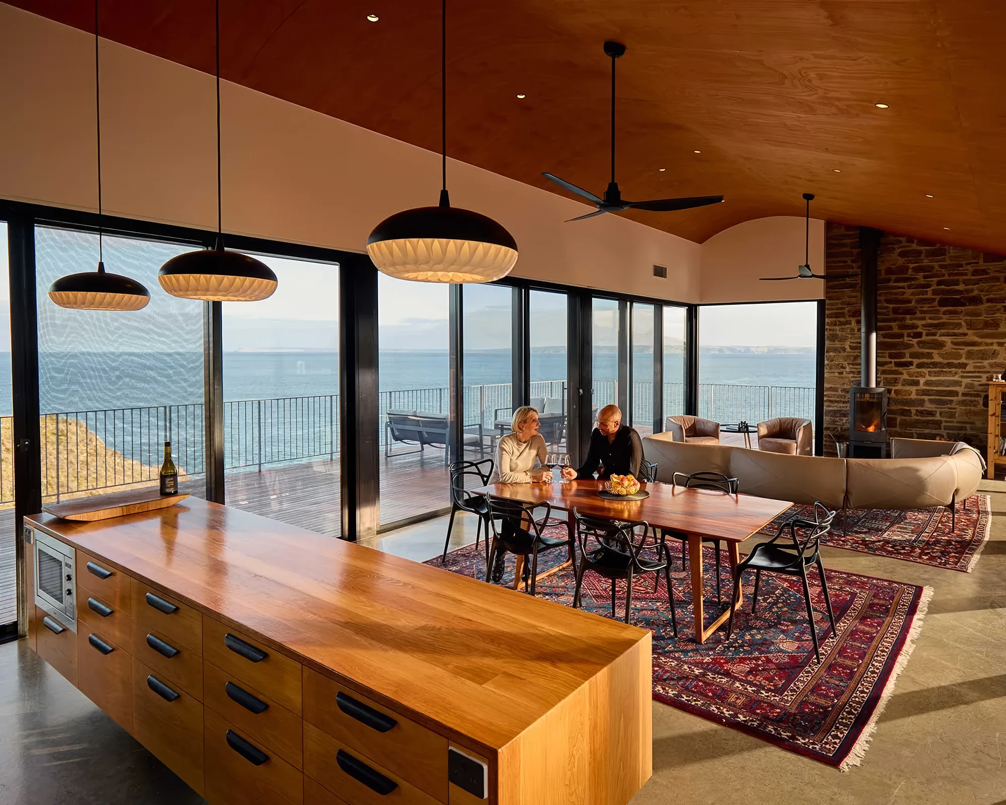 The long dining table under pendant lights with sea views