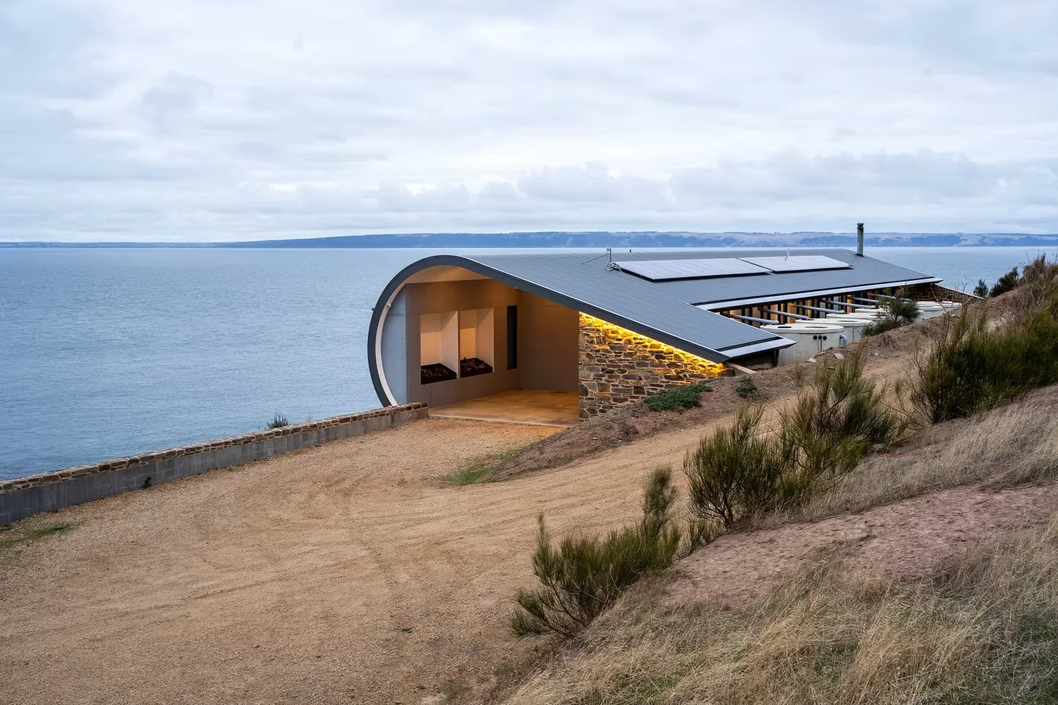The wave-form roofline of Naiko Retreat with the Southern Ocean behind