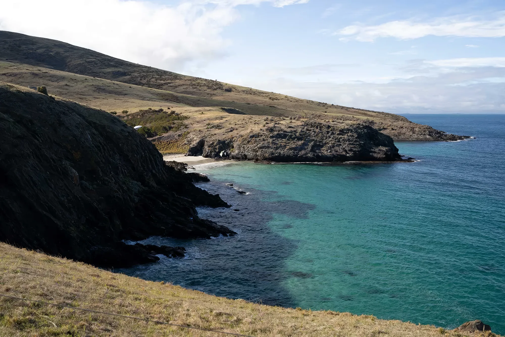 A headland and clear green water along the coast