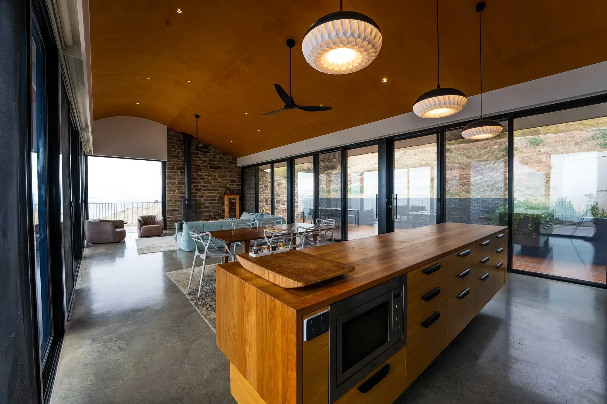 Timber kitchen island beneath the curved ceiling