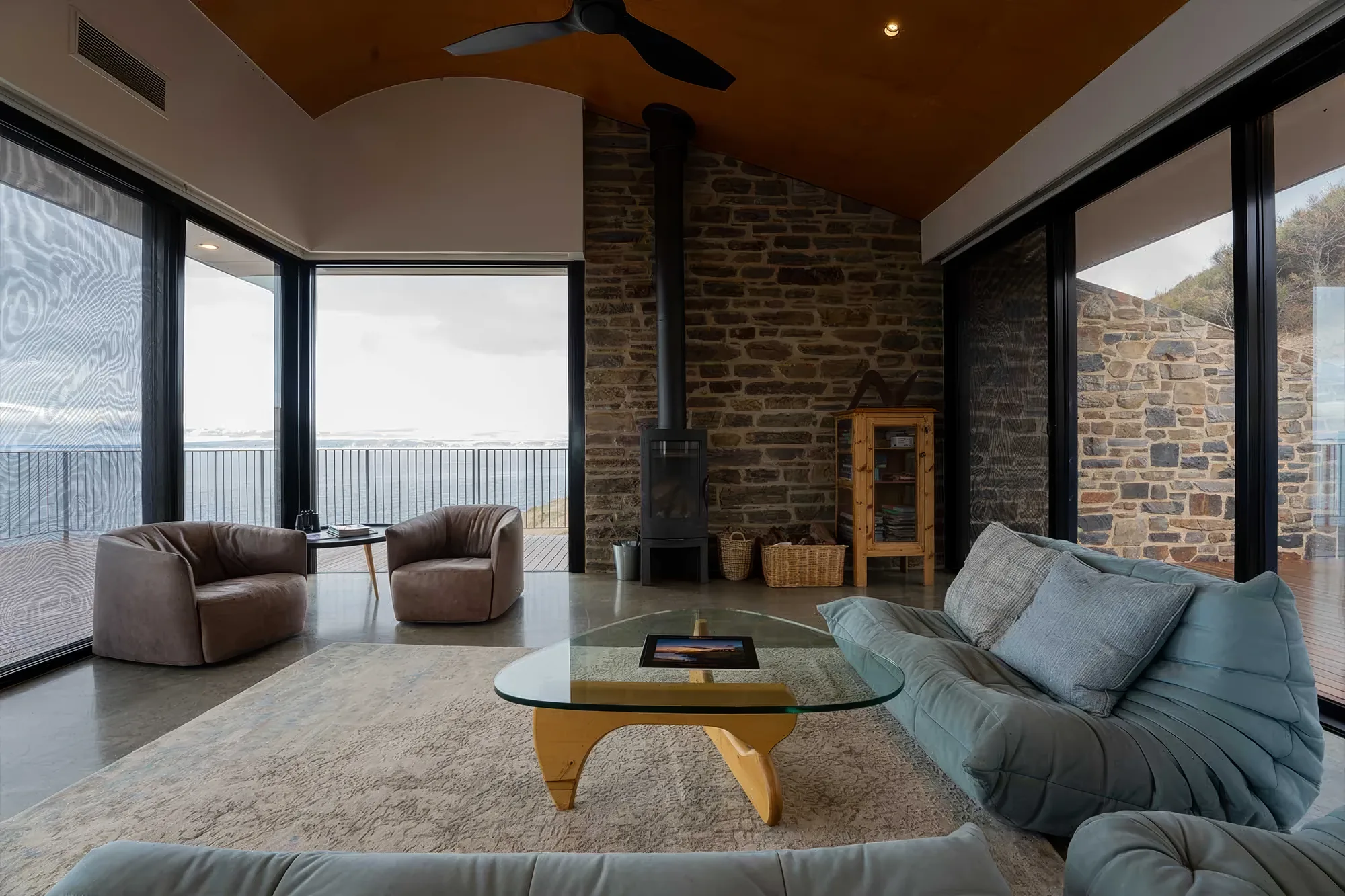 The living area with the wood fire and coastal outlook