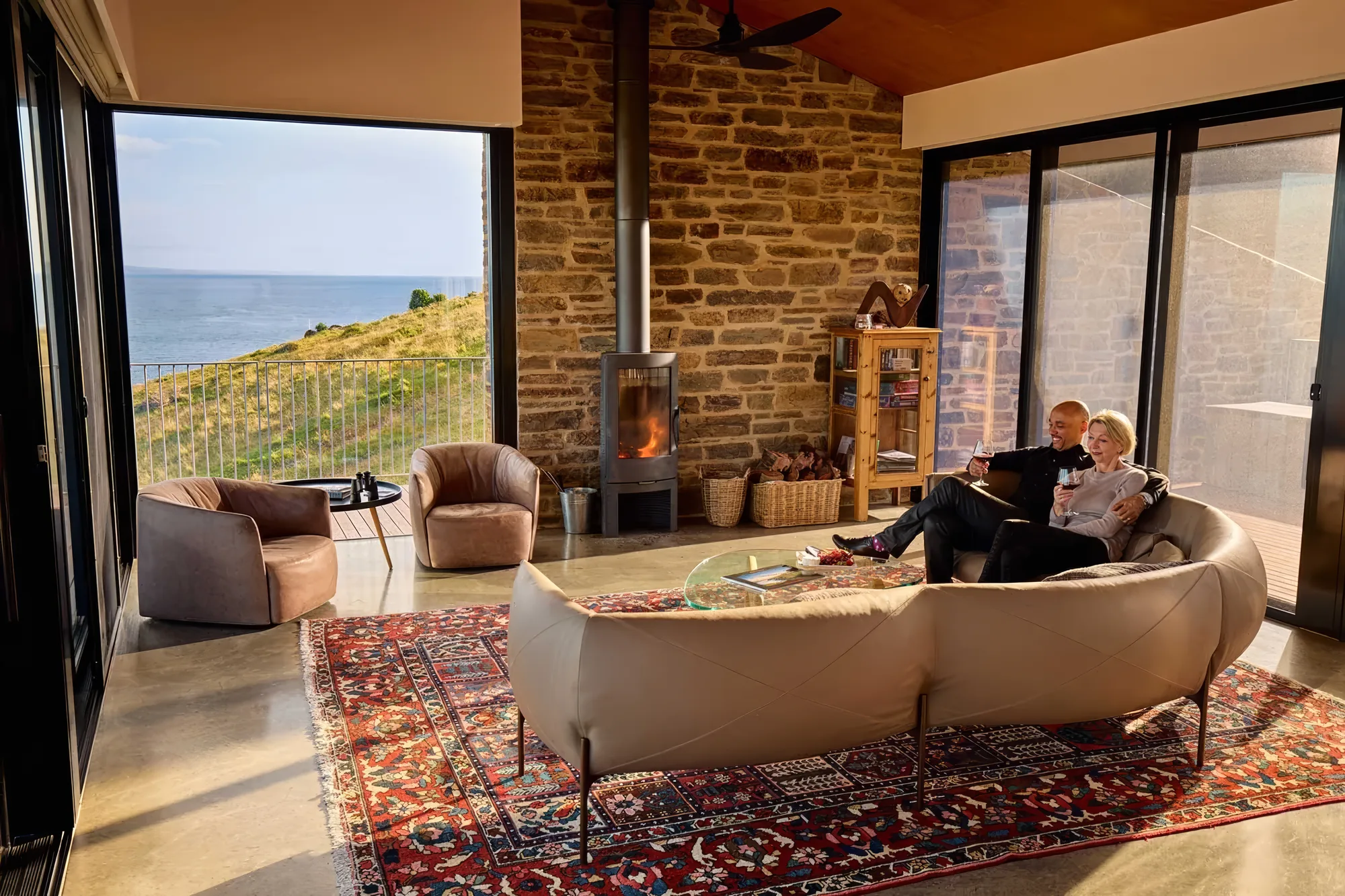Guests reading beside the fire in the living room