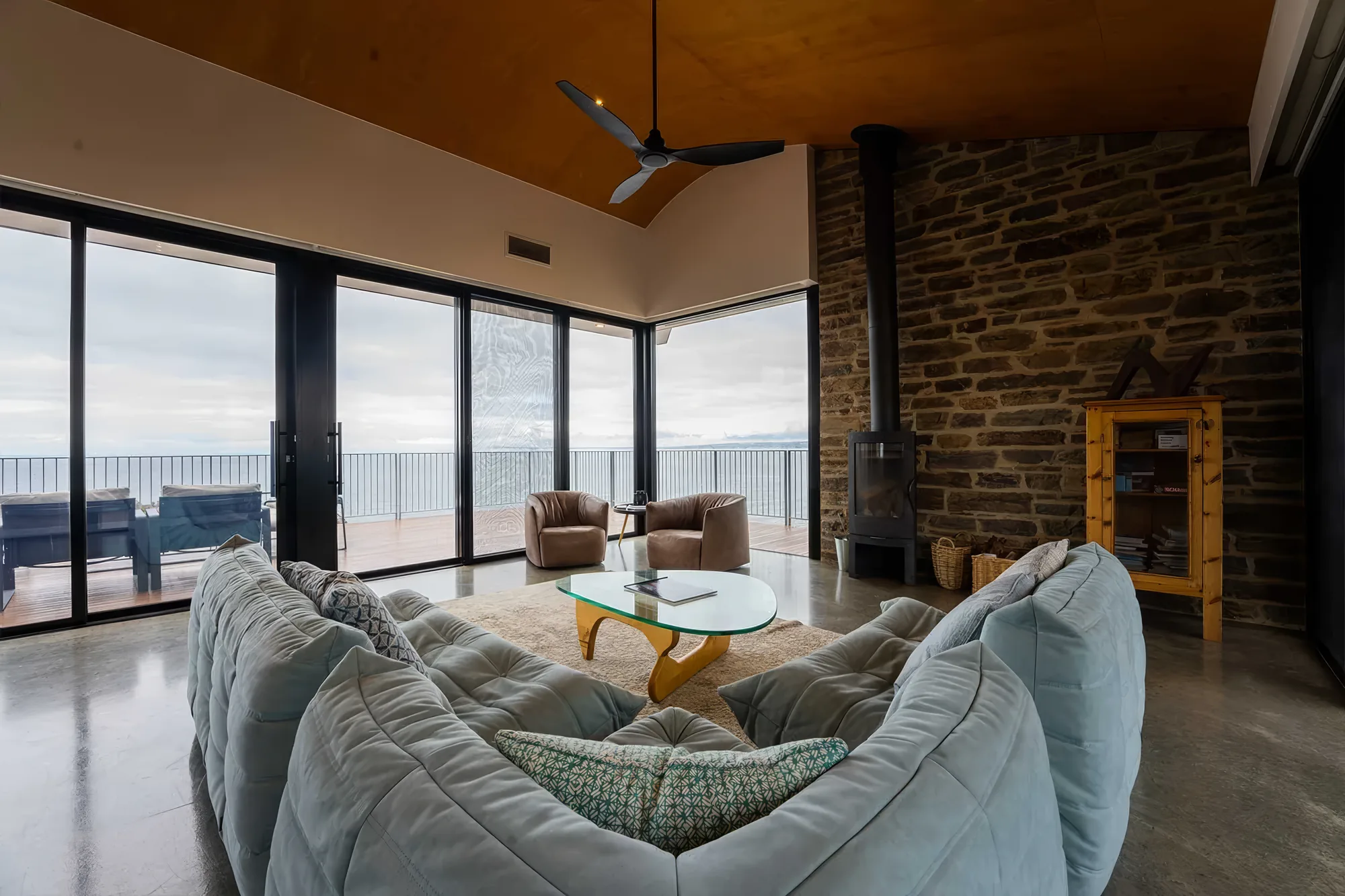 Lounge seating facing the full-height windows and the ocean