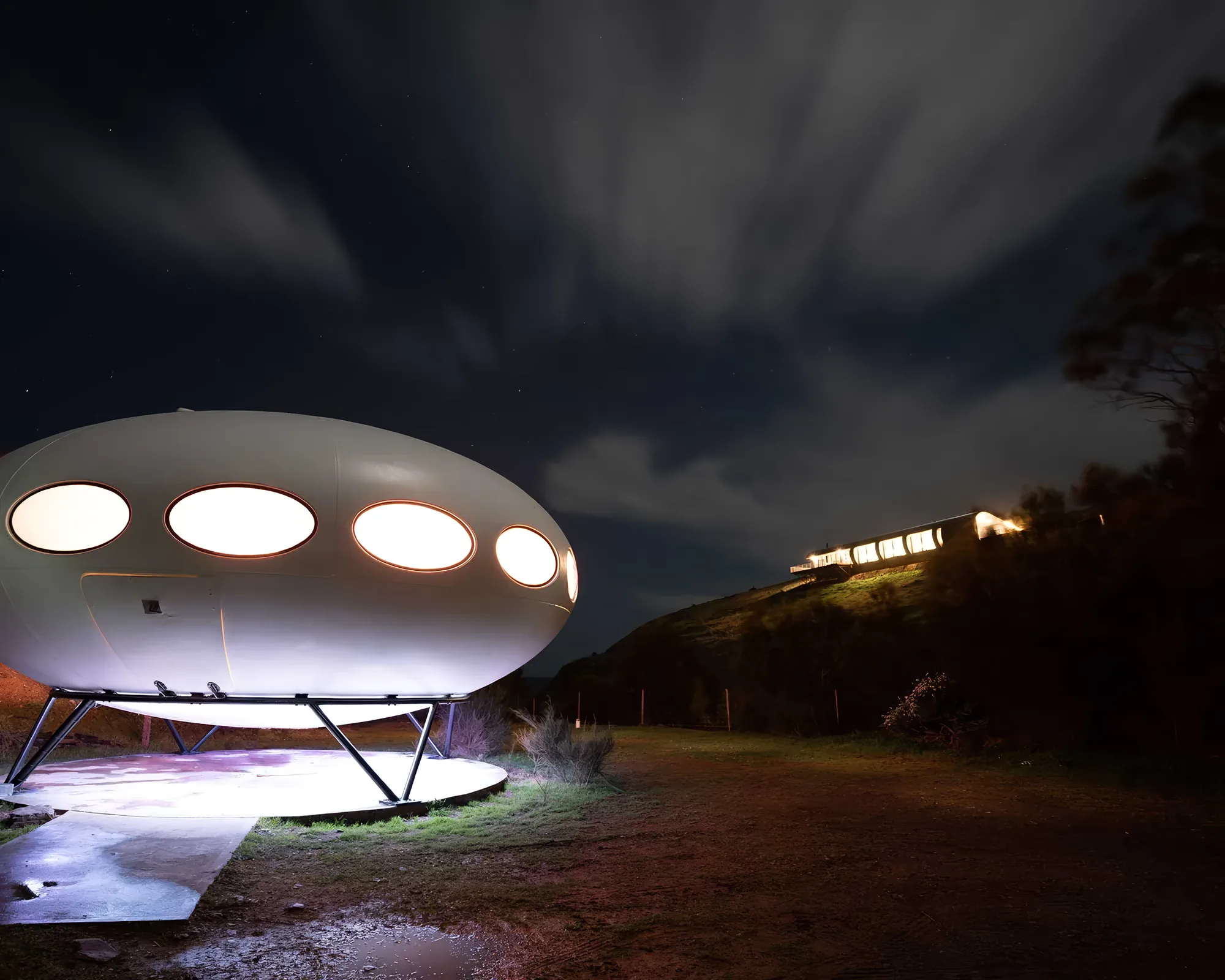 The Futuro glowing after dark beside Naiko Inlet
