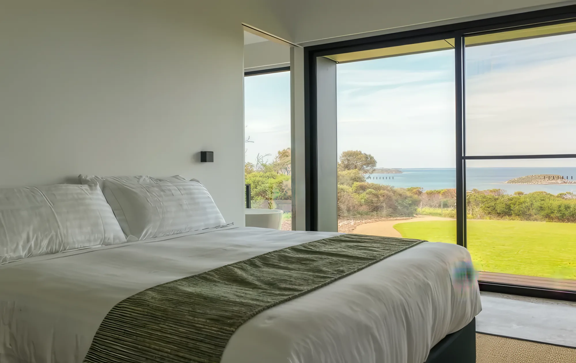 A king bed facing the windows and Encounter Bay