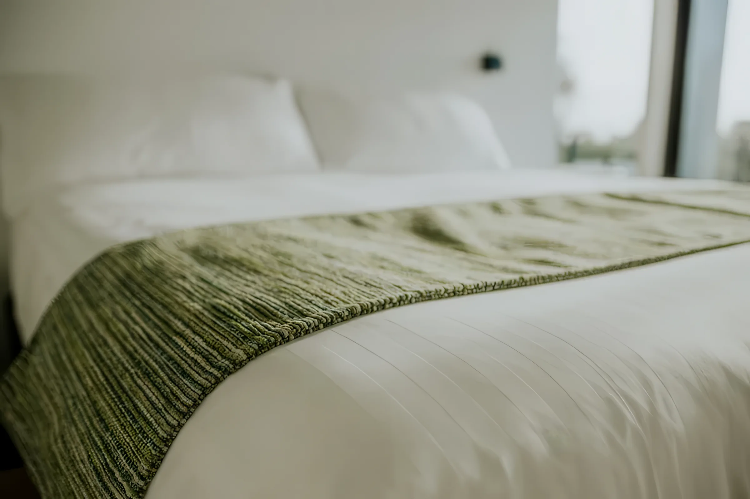Made bed with layered linen at The Villa