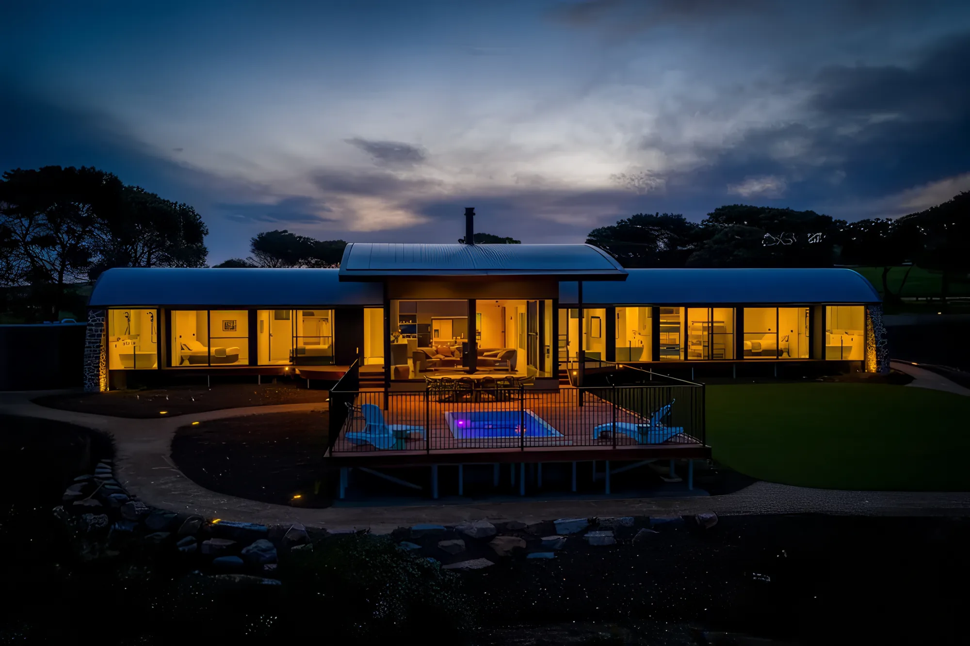 The Villa at Naiko at the Bluff lit at dusk, its pool glowing beside the deck