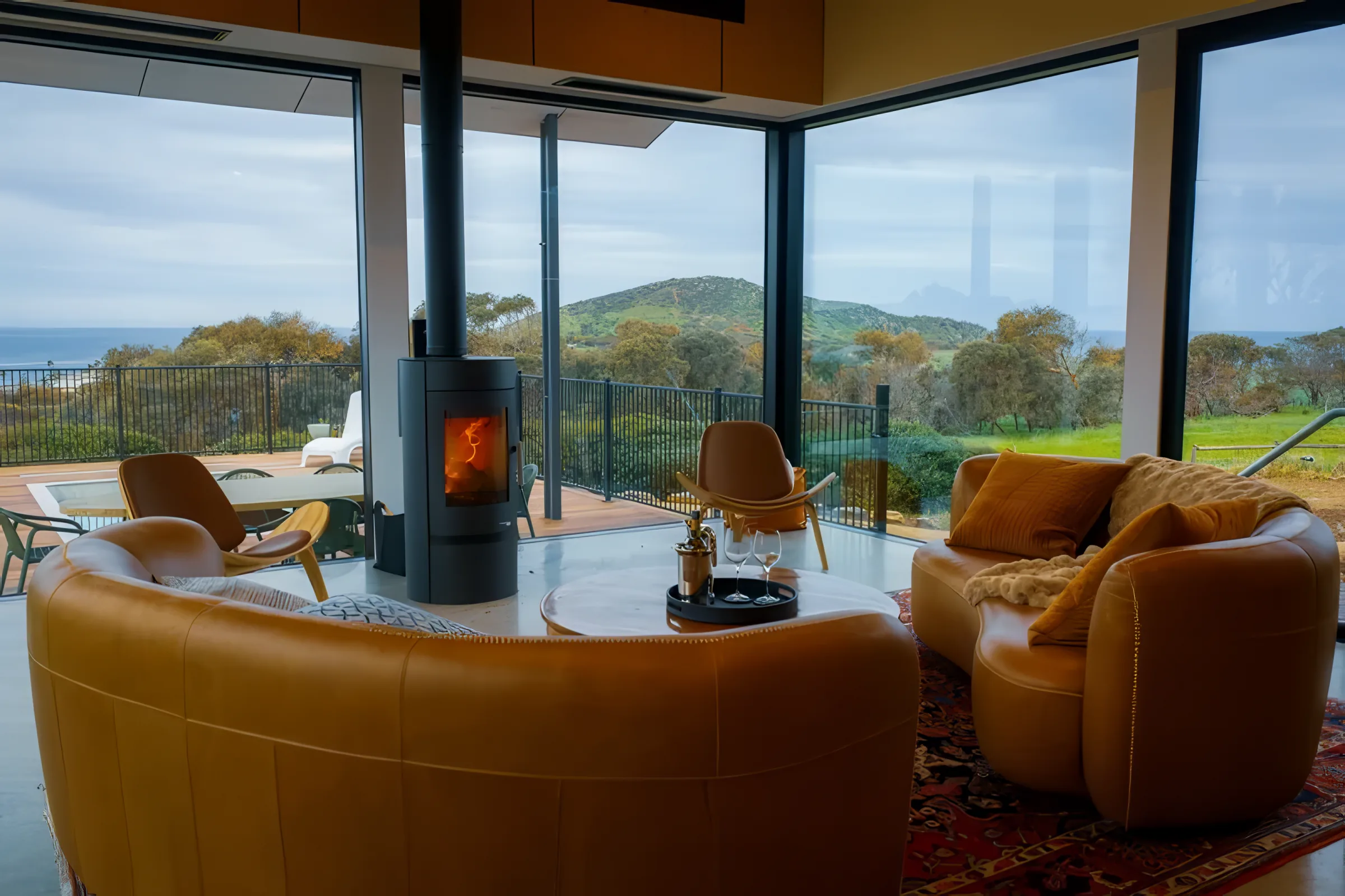 Lounge seating around the fire, framed by full-height glass