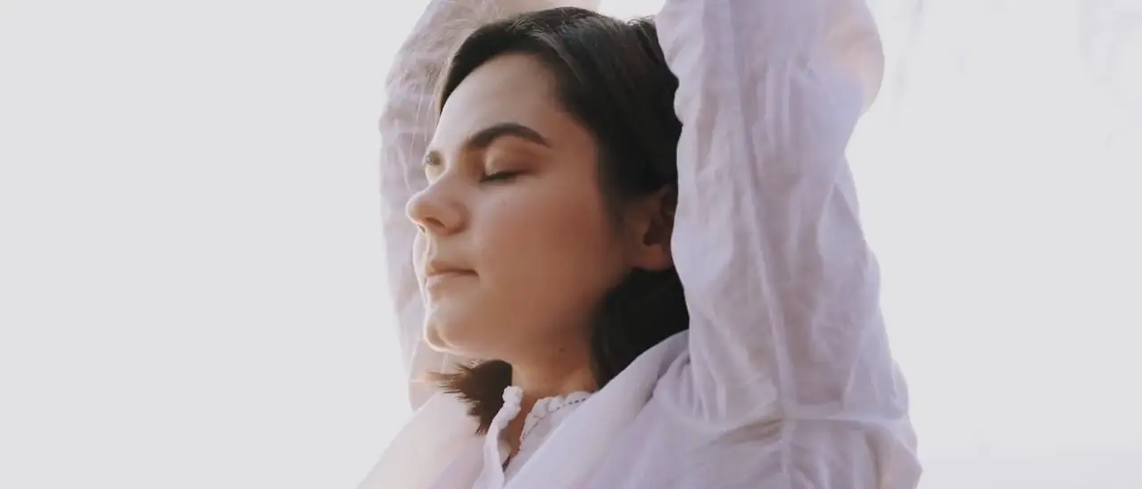 A guest stretching slowly against a bright open sky